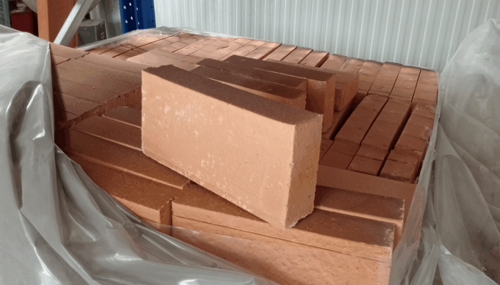Ladrillos refractarios apilados en almacén de Comercial Amador en Lalín.